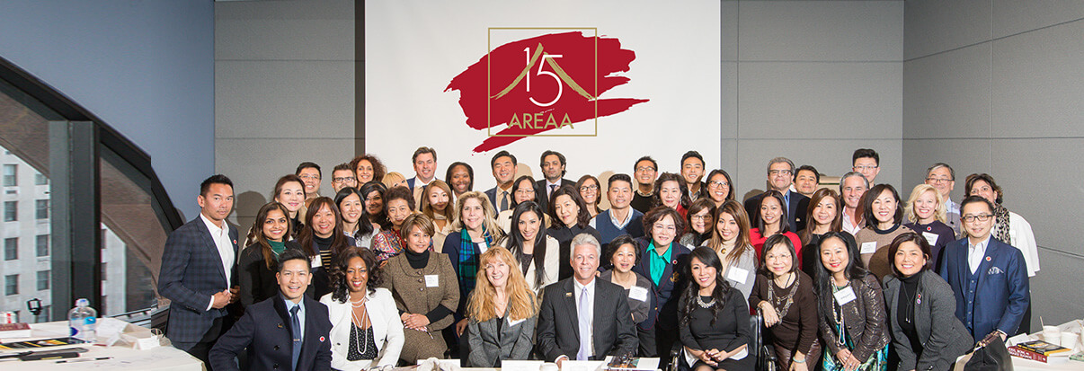 a picture of AREAA members in front of AREAA logo